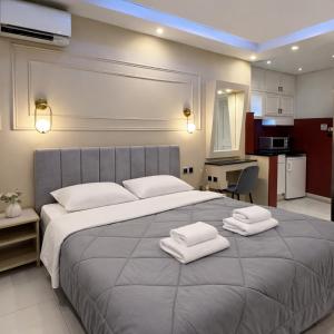 a bedroom with a large bed with towels on it at NOHO Boutique Koukaki , premium living in Athens