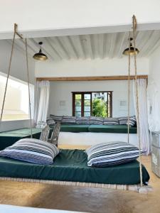 a group of four beds in a room at Shela Bahari in Shela