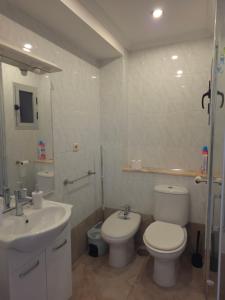 a bathroom with a white toilet and a sink at Beach view apartment in Cullera in Cullera +36 photos