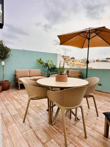 a table and chairs with an umbrella on a patio at 248 Boutique Studios, Boutique Hotel, Sliema in Sliema