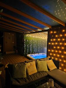 a room with a couch and a bed with lights at Drum Farm Hideaways in Carron
