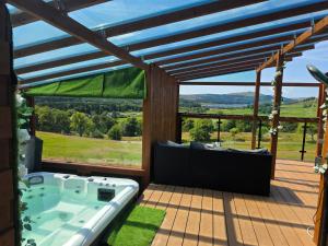 a hot tub on a deck with a view at Drum Farm Hideaways in Carron +6 photos