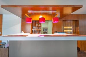 a kitchen with red pendant lights over a counter at Treebo New Indraprastha in Kilimanūr