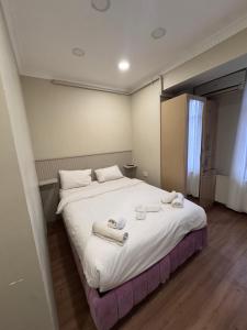 a bedroom with a large bed with towels on it at RENOVA hOTEL FATİH in Istanbul