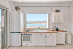 a kitchen with a white refrigerator and a window at Antiparos Thea in Antiparos +7 photos