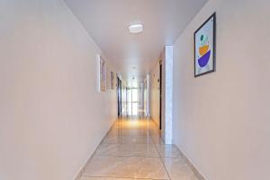 a hallway with white walls and a tile floor at Treebo New Indraprastha in Kilimanūr