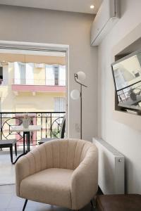 a living room with a chair and a balcony at NOHO Boutique Koukaki , premium living in Athens