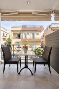 a patio with two chairs and a table on a balcony at NOHO Boutique Koukaki , premium living in Athens