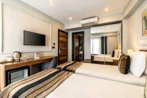 a hotel room with two beds and a television at Zalel Hotels Laleli in Istanbul