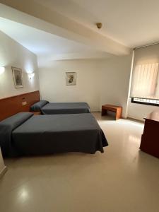a bedroom with two beds and a window at Hotel lázaro in Calamocha