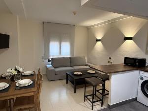 a kitchen and living room with a couch and a table at Hotel lázaro in Calamocha