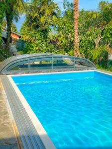 a blue swimming pool with a bridge over it at Casa Lago in Germignaga