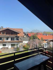 a view from the balcony of a building with a bench at Ferienwohnung Hörnernest in Bolsterlang