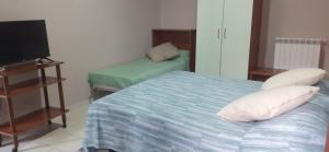 a small bedroom with a bed and a television at Nexus 2, Recale, Campania in Recale