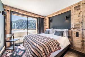 a bedroom with a bed and a large window at Apartment Clano, Châtel - by EMERALD STAY in Châtel