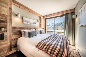 a bedroom with a large bed and a window at Apartment Clano, Châtel - by EMERALD STAY in Châtel