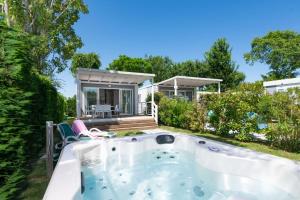 a hot tub in the backyard of a house at Villaggio Camping Adria in Casal Borsetti