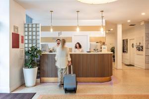 a man with a suitcase walking through a lobby at Pestana South Beach Miami in Miami Beach