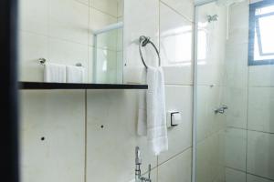 a bathroom with a shower with a towel and a sink at Quitinete inteligente Centro da Cidade Unidade 1 in Presidente Prudente +93 photos