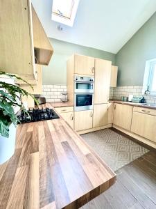 a kitchen with wooden cabinets and a wooden counter top at Newcastle Pet friendly 1 bed drive garden 10m city in Kenton