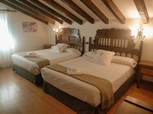 a bedroom with two beds with white sheets at Posada Spa San Marcos in Santillana del Mar +69 photos