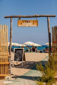 a chalk board on the beach with umbrellas at Albergo Diffuso Mannois in Orosei