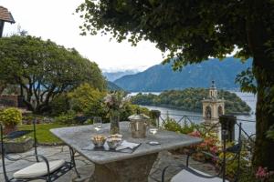 a picnic table with a view of a river and mountains at Villa Regina in Sala Comacina