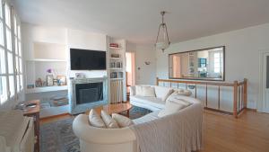 a living room with two white couches and a fireplace at Villa Regina in Sala Comacina