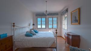 a bedroom with a bed with blue pillows on it at Villa Regina in Sala Comacina