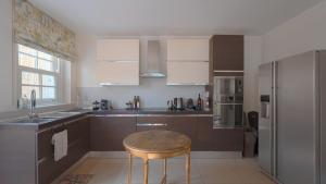 a kitchen with a table and a stainless steel refrigerator at Villa Regina in Sala Comacina
