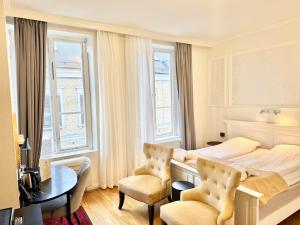 a bedroom with a bed and two chairs and a table at Hotel Concordia in Lund +184 photos