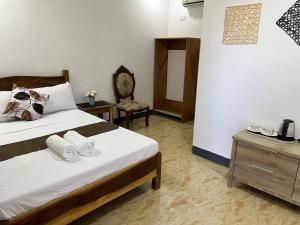a bedroom with a bed with towels on it at Luzviminda Farm Homestay in Coron