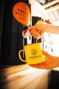 a person is holding a yellow coffee cup at Aguas de Ibias in Cecos +17 photos