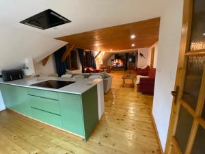 a kitchen with a counter top and a living room at Hunters Lodge in Liptovská Lúžna