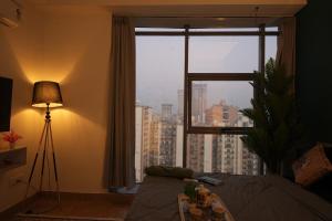 a living room with a window with a view of a city at Spectrum Mall 1BHK Balcony Suite in Noida +2 photos