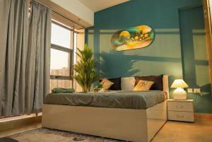 a bedroom with a bed with a painting on the wall at Spectrum Mall 1BHK Balcony Suite in Noida