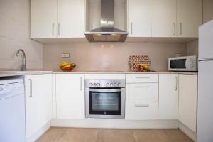 a kitchen with white cabinets and a microwave at INASS in Sitges