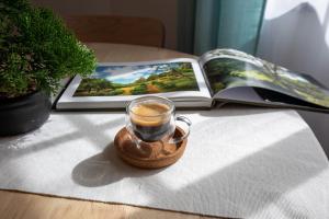 a cup of coffee on a table next to a book at Casa do Lado, Flores Açores in Lajes das Flores