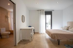 a bedroom with a bed and a bathroom with a toilet at INASS in Sitges