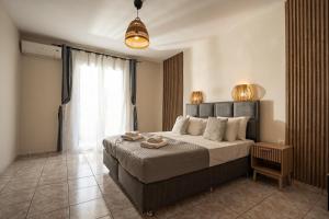 a bedroom with a bed and a large window at Aggire Summer Suites in Alikanas
