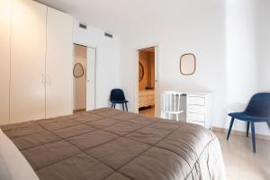 a bedroom with a large bed and two blue chairs at INASS in Sitges +8 photos