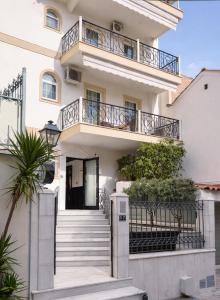 a white house with a staircase and a balcony at NOHO Boutique Koukaki , premium living in Athens