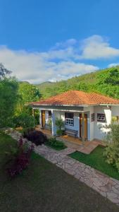 a small white house with a garden at Pousada da Serrinha in Mariana