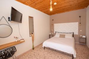 a bedroom with a bed and a flat screen tv at Elves Studios& Apartment's SIDARI in Sidari
