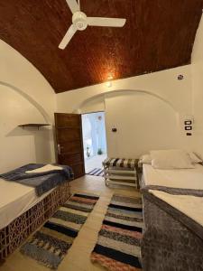 a bedroom with two beds and a ceiling fan at Turia Hotel in Aswan
