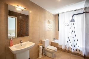 a bathroom with a sink and a toilet and a shower curtain at INASS in Sitges