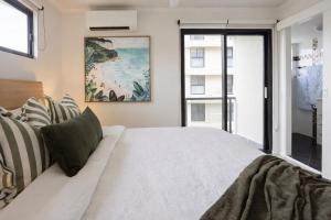 a bedroom with a large white bed and a window at Summer Cove on the Ocean with Pool in Coolum Beach +25 photos