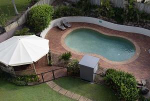 an overhead view of a swimming pool with an umbrella and chairs at Summer Cove on the Ocean with Pool in Coolum Beach
