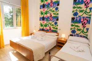 a bedroom with two beds and a window at LUDO Holiday House in Riccione