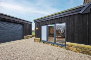a black house with windows and a garage at The Churchside Well in Ravenscar